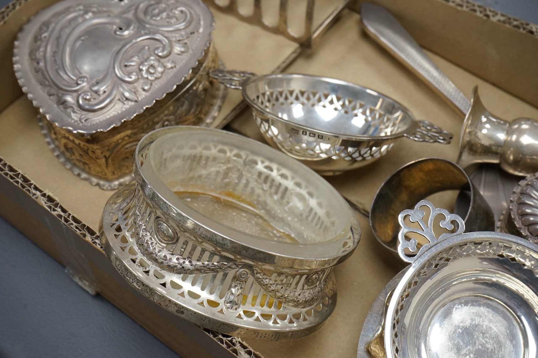 A group of small collectable silver including a late Victorian heart shaped trinket box, Chester, 1899, length 92mm (a.f.), a coaster, toast rack, spill vase, small trinket box, a pair of two handled dishes, napkin ring,